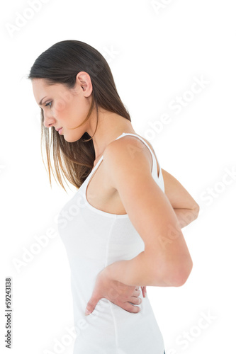 Photo: Casual young woman suffering from back pain Casual young woman suffering from back pain