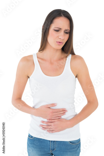 Photo: Displeased casual young woman with stomach pain Displeased casual young woman with stomach pain