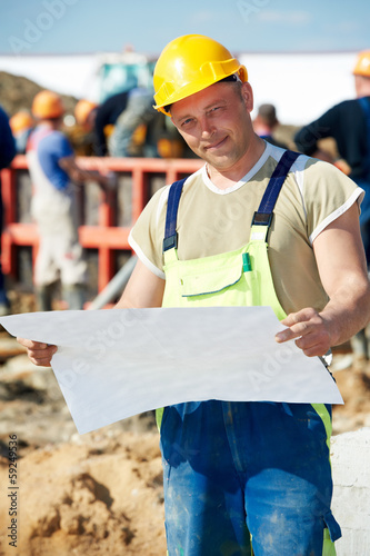 Photo: Engineer builders at construction site with draft Engineer builders at construction site with draft