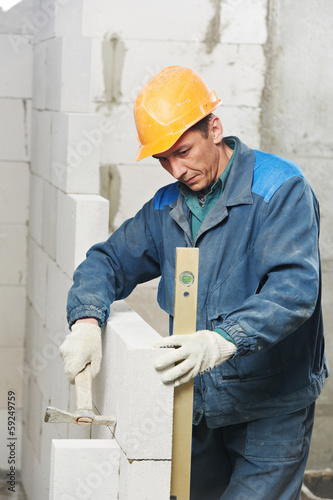Photo: construction mason worker bricklayer with level construction mason worker bricklayer with level