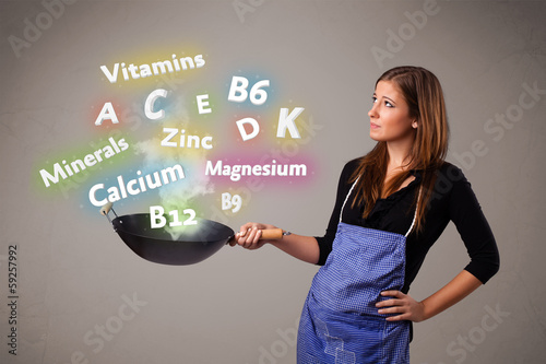 Photo: Young woman cooking vitamins and minerals Young woman cooking vitamins and minerals