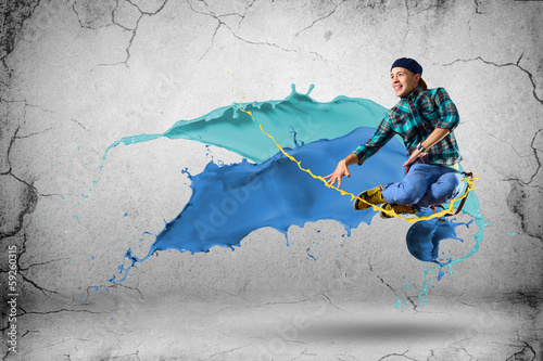 Photo: young male dancer jumping with splash of paint young male dancer jumping with splash of paint