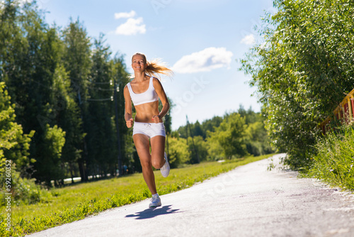 Photo: young athletic woman running on the road young athletic woman running on the road