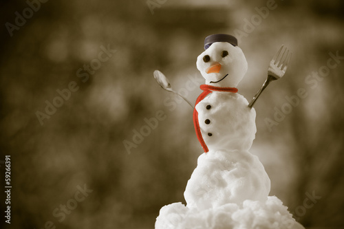 Photo: Little happy christmas snowman with fork outdoor. Winter season. Little happy christmas snowman with fork outdoor. Winter season.