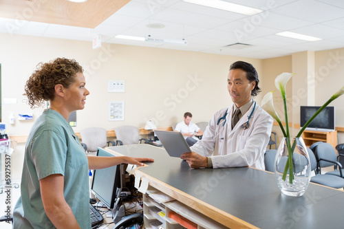 Photo: Nurse And Doctor Conversing At Hospital Reception Nurse And Doctor Conversing At Hospital Reception