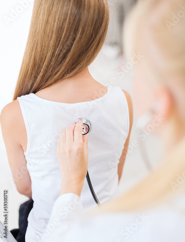 Photo: doctor with stethoscope listening to child back doctor with stethoscope listening to child back