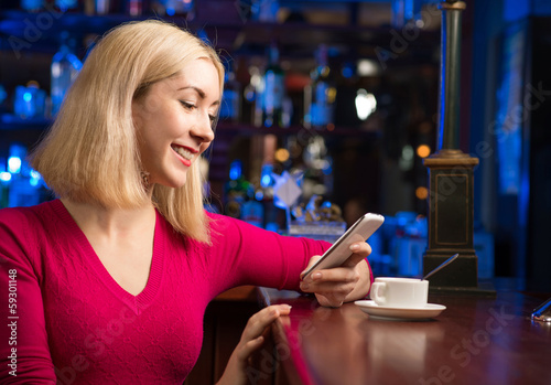 Photo: woman with a cup of coffee and cell phone woman with a cup of coffee and cell phone