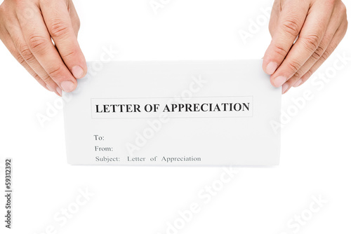 Photo: hands holding a letter of appreciation with clipping path hands holding a letter of appreciation with clipping path