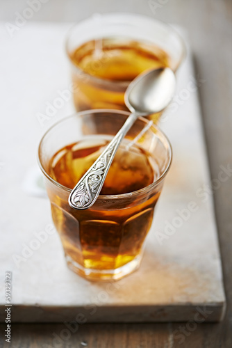Photo: Two glasses of rooibos tea (focus on the spoon) Two glasses of rooibos tea (focus on the spoon)