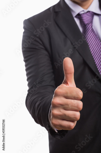 Photo: Mid section of a businessman gesturing thumbs up Mid section of a businessman gesturing thumbs up