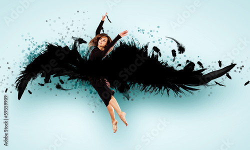 Photo: Woman floating on dark wings Woman floating on dark wings