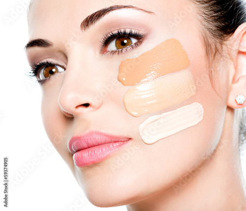 Photo: Beautiful face of woman with cosmetic foundation on a skin. Beautiful face of woman with cosmetic foundation on a skin.