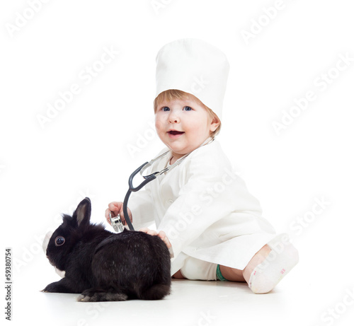 Photo: kid with clothes of doctor playing with pet bunny kid with clothes of doctor playing with pet bunny