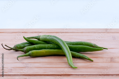 Photo: green chillies on chopping board green chillies on chopping board