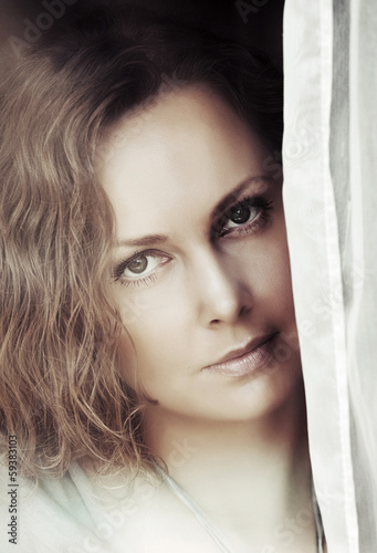 Photo: Portrait of beautiful woman looking out the window Portrait of beautiful woman looking out the window