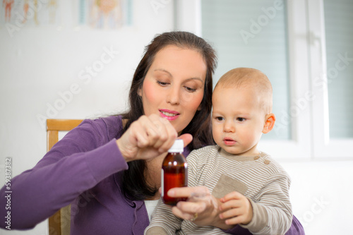 Photo: Mother giving medicine to baby Mother giving medicine to baby