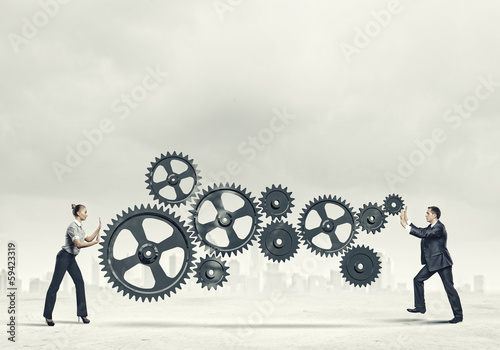 Photo: Business people and mechanism elements Business people and mechanism elements