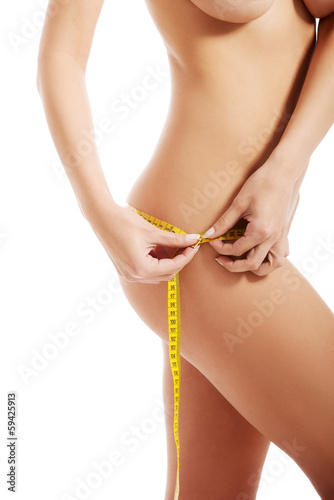 Photo: Beautiful female's thigh with measuring tape. Beautiful female's thigh with measuring tape.