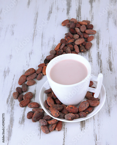 Photo: Cocoa drink and cocoa beans on wooden background Cocoa drink and cocoa beans on wooden background