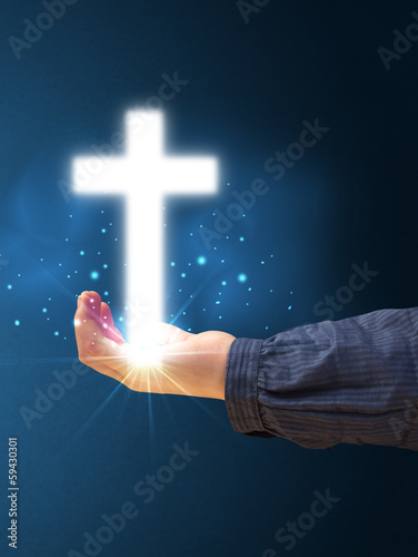 Photo: Glowing cross in the hand of a woman Glowing cross in the hand of a woman