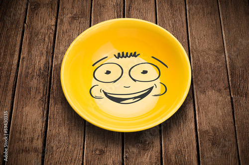 Photo: Happy smiley cartoon face on colorful dish plate Happy smiley cartoon face on colorful dish plate