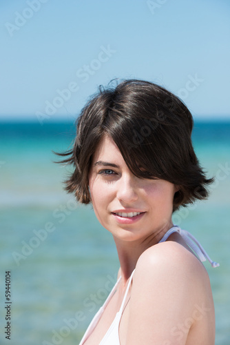 Photo: schöne frau am meer schaut über ihre schulter schöne frau am meer schaut über ihre schulter