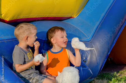 Photo: Two young friends eating candy floss Two young friends eating candy floss