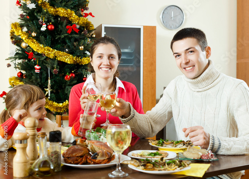 Photo: Happy family celebrating Christmas over celebratory table Happy family celebrating Christmas over celebratory table