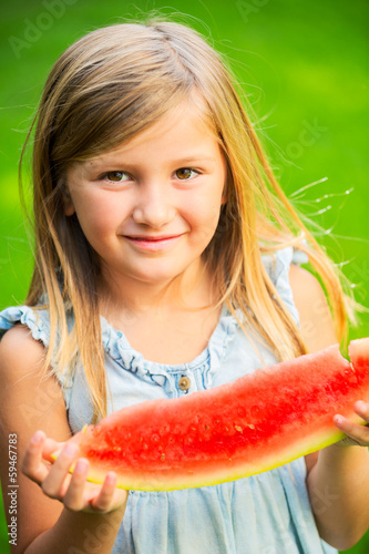 Photo: Cute little girl eating watermelon Cute little girl eating watermelon