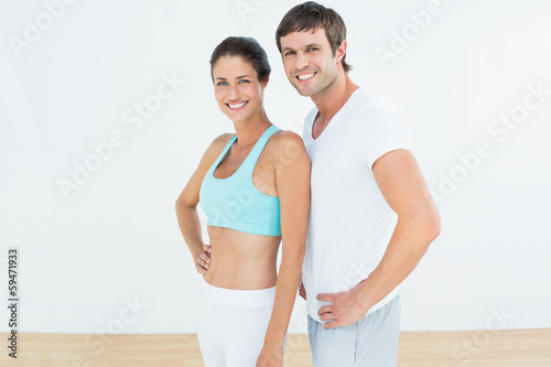Photo: Portrait of a fit couple in fitness studio Portrait of a fit couple in fitness studio