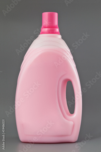 Photo: Transparent detergent plastic bottle isolated on gray Transparent detergent plastic bottle isolated on gray