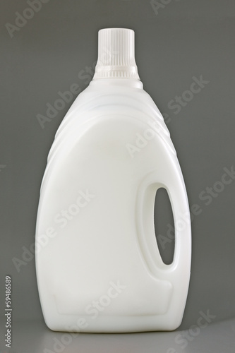 Photo: Transparent detergent plastic bottle isolated on gray Transparent detergent plastic bottle isolated on gray