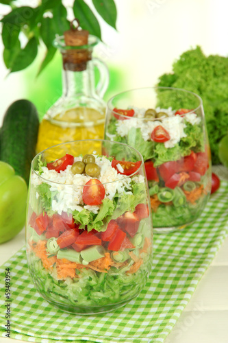 Photo: Tasty salad with fresh vegetables on wooden table Tasty salad with fresh vegetables on wooden table