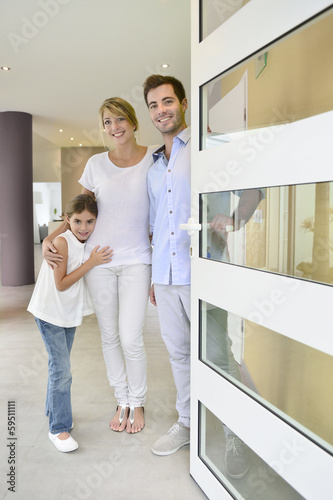 Photo: Family standing at front door to invite people in Family standing at front door to invite people in