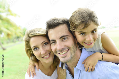 Photo: Portrait of happy family standing in park Portrait of happy family standing in park