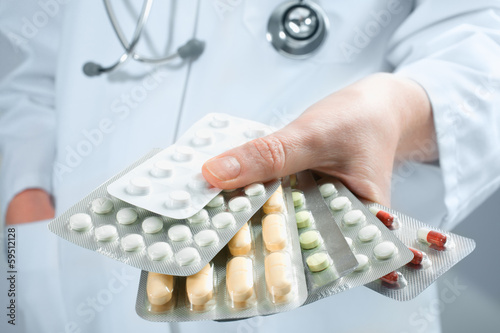 Photo: Hand of doctors holding many different pills Hand of doctors holding many different pills