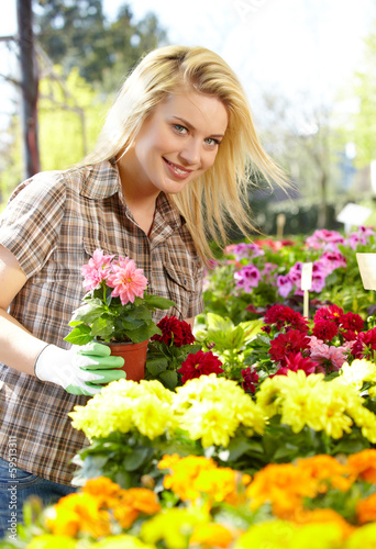 Photo: Florists woman working with flowers at a greenhouse. Florists woman working with flowers at a greenhouse.