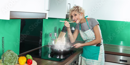 Photo: Young woman cook or housewife Young woman cook or housewife