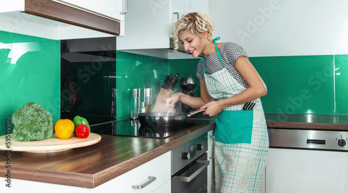 Photo: Young woman cook or housewife Young woman cook or housewife