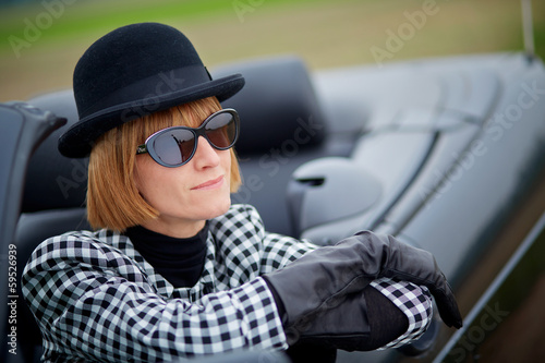 Photo: 40s woman with sunglasses in a cabriolet 40s woman with sunglasses in a cabriolet