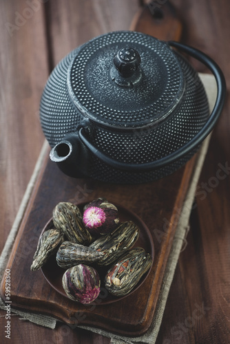 Photo: Green tea balls and cast-iron teapot on a wooden surface Green tea balls and cast-iron teapot on a wooden surface