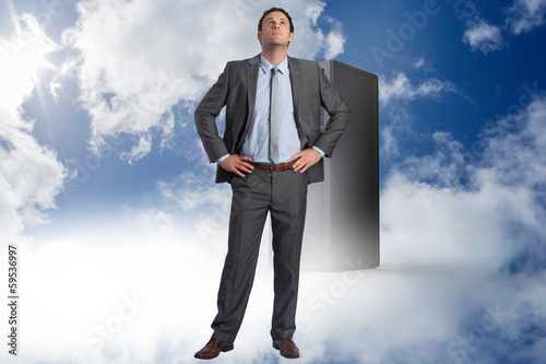 Photo: Composite image of serious businessman with hands on hips Composite image of serious businessman with hands on hips
