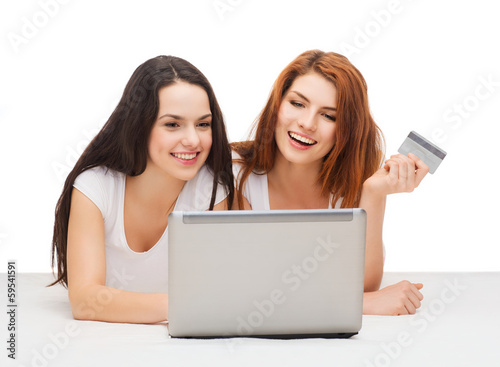 Photo: two smiling teenagers with laptop and credit card two smiling teenagers with laptop and credit card