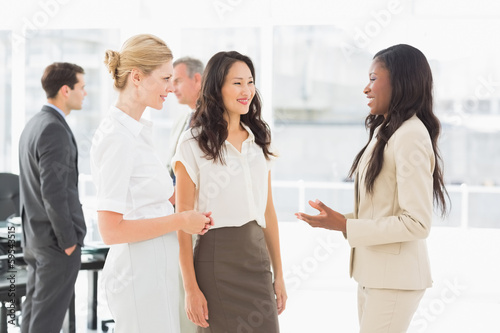 Photo: Businesswomen speaking together in conference room Businesswomen speaking together in conference room