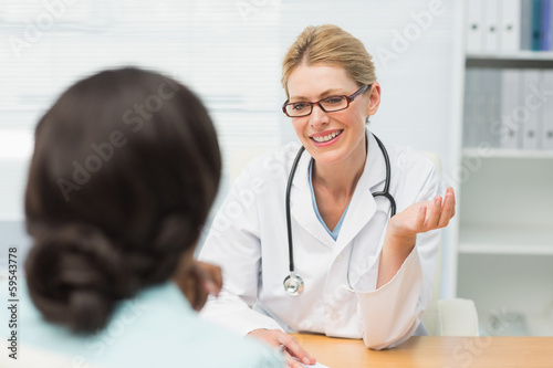 Photo: Smiling doctor talking to her patient Smiling doctor talking to her patient