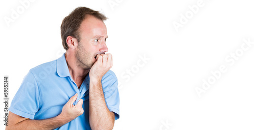 Photo: Stressed young man biting his fingernails, looking anxious Stressed young man biting his fingernails, looking anxious