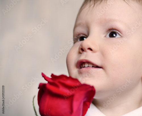 Photo: Adorable cherubic little boy with a red rose Adorable cherubic little boy with a red rose