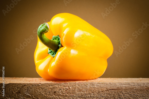 Photo: Yellow bell pepper on wooden table. Clipping path Yellow bell pepper on wooden table. Clipping path
