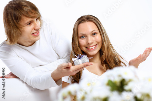 Photo: Young couple at home with present Young couple at home with present