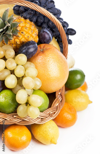 Photo: Fresh fruit in a wicker basket isolated on the white Fresh fruit in a wicker basket isolated on the white